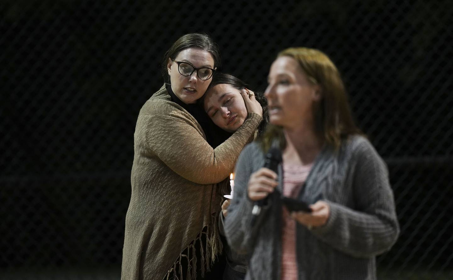 Kristin Karopchinsky holds a loved one while Tracy Karopchinsky speaks at the vigil