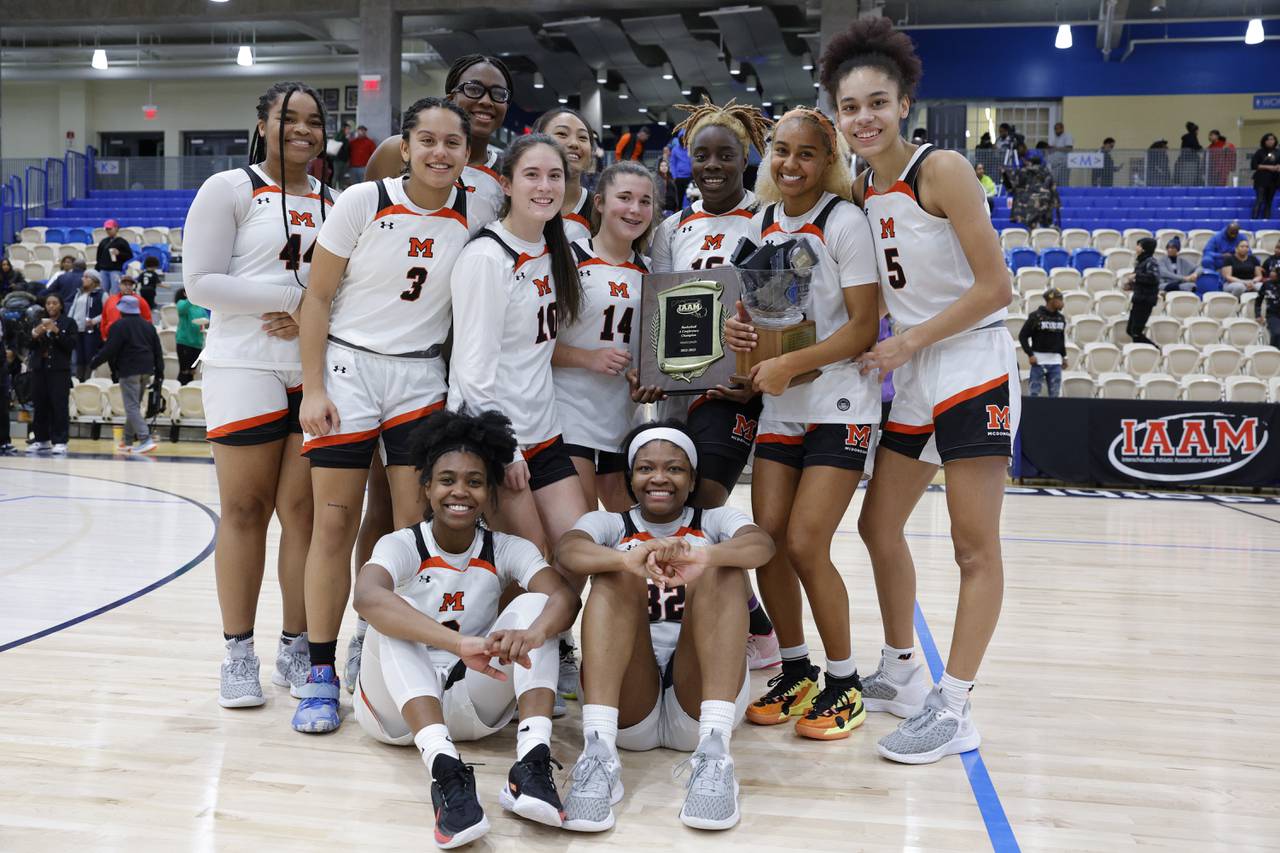 McDonogh players pose for a photo with medals and trophies following the IAAM A Girls Championship game in Bel Air, Md., on Monday, February 20, 2023. McDonogh defeated St. Frances 50-47 to win the championship.