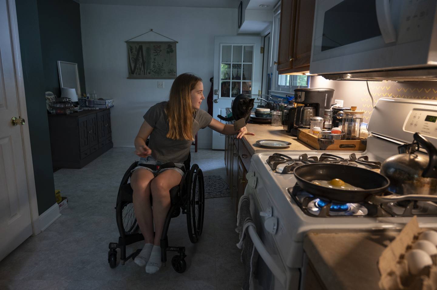 Anneliese Williams, 22, makes herself breakfast. Her decreased mobility doesn't stop her from living her daily life.