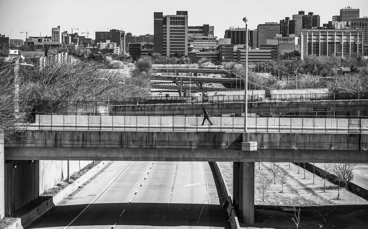 A pedestrian pass over a bridge above U.S. Route 40 in Baltimore, Wednesday, March 8, 2023.