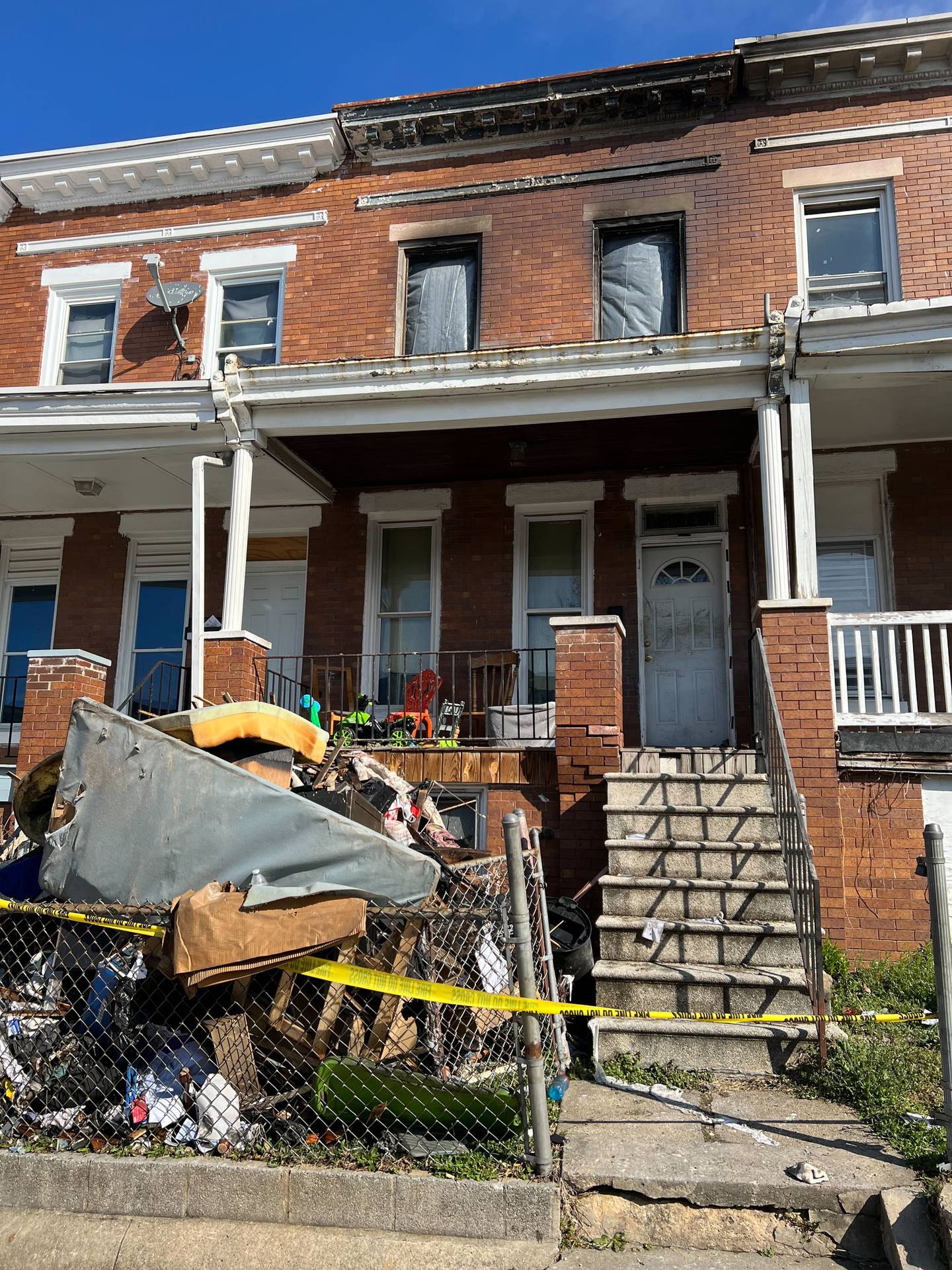Three children died and two adults were critically injured in an early-morning house fire in West Baltimore. Burned belongings are piled up outside the home in the 3000 block of Brighton Street.