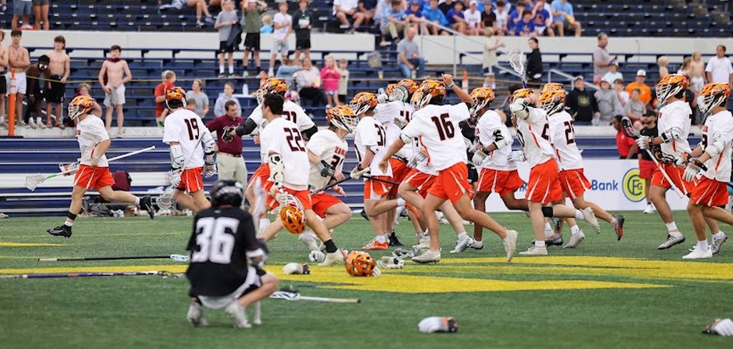 Boys' Latin's defensemen Matthew Higgins (36) kneels as McDonogh celebrates victory in the MIAA A Conference lacrosse semifinals. The No. 1 Eagles defeated the fourth-ranked Lakers, 8-7, in overtime at Navy-Marine Corps Memorial Stadium in Annapolis.
