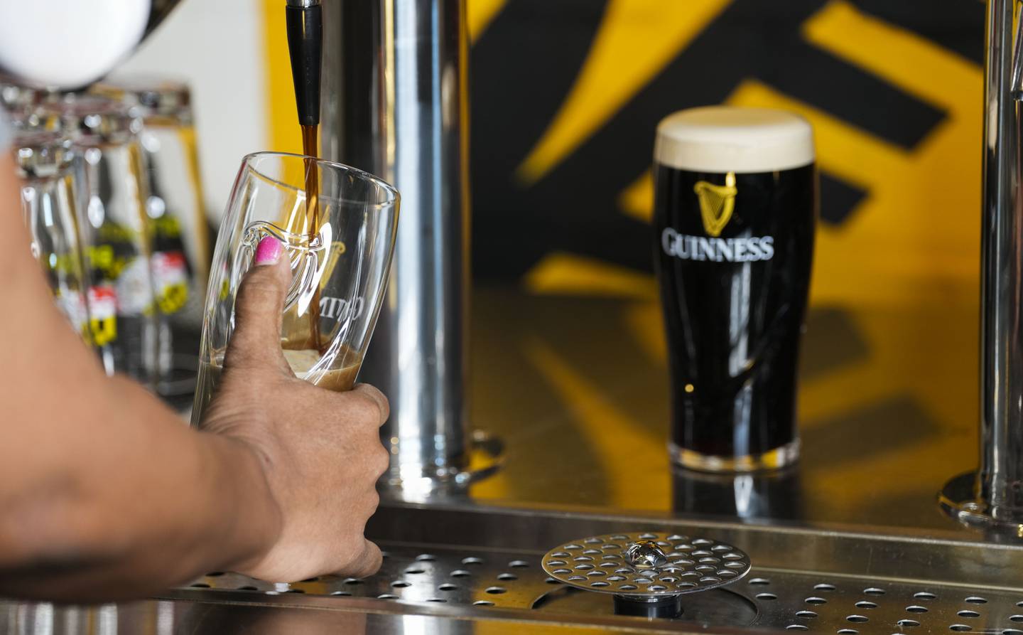 Baltimore Banner columnist Leslie Streeter learns from Oliver Gray how to craft the "perfect pour" of a Guinness draft at the Baltimore Guinness location on March 14, 2023.