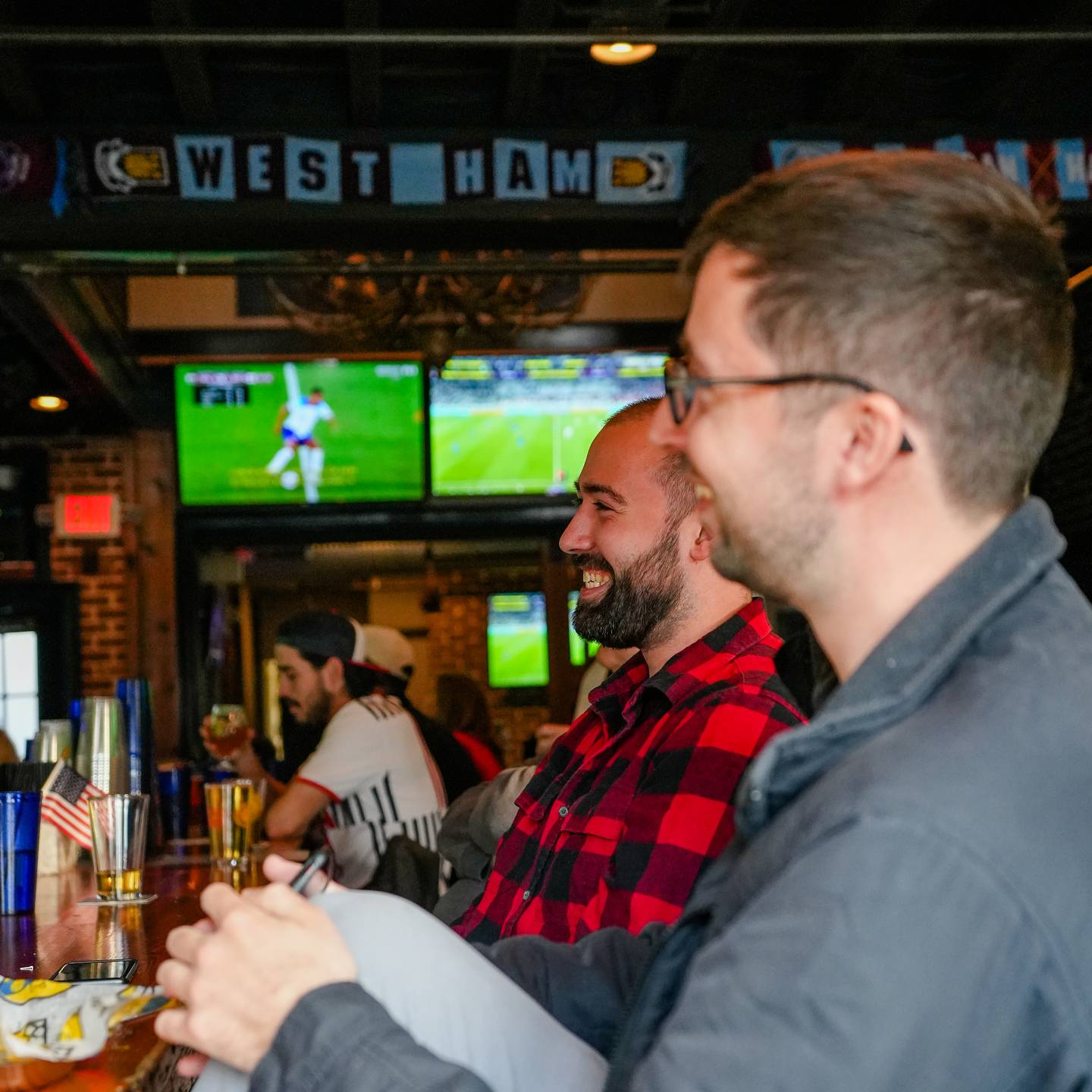 Brothers, Joey Fluehr, 24, (left) and Ryan Fluehr, 29, share some good laughs while watching the USA vs. Iran World Cup match at Abbey Burger in Little Italy, Baltimore, Md., on November 29, 2022.