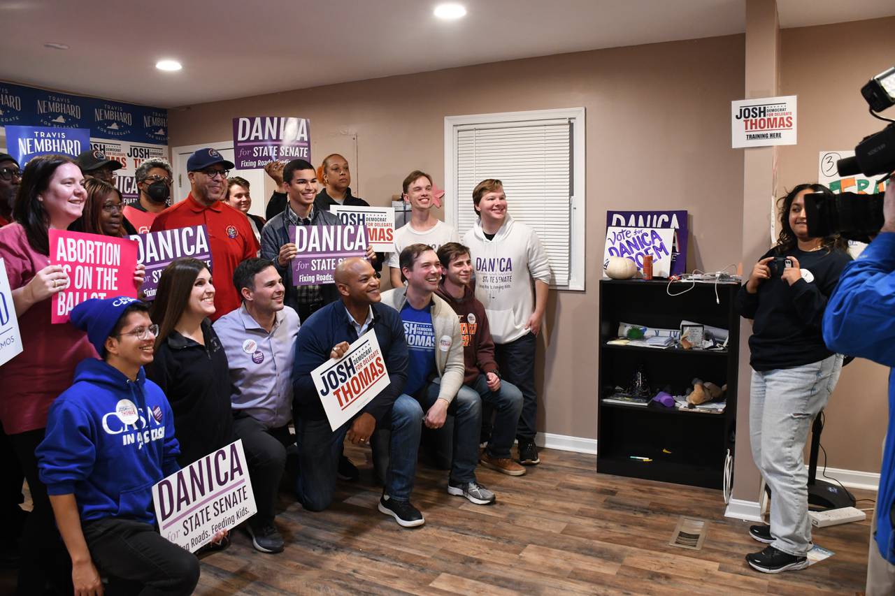 Maryland Gov. Wes Moore poses for pictures with Democratic candidates and workers in Manassas, Va. at the end of a day of campaigning across the state on Saturday, Nov. 4, 2023.