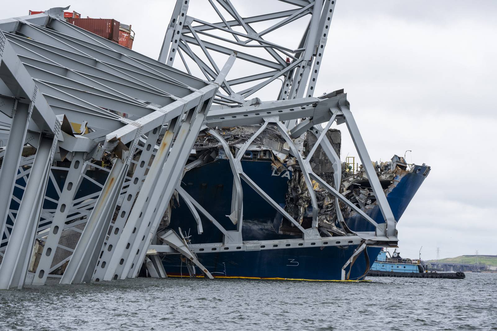The Dali, a massive container ship from Singapore,  still sits in the wreckage and collapse of the Francis Scott Key Bridge in the Baltimore port on April 1, 2024. It has been a week since it lost power and struck the bridge , causing it to topple in seconds, taking several roadway workers and their cars with it. The once giant frame of the bridge now sits in the water and large cranes have arrived to untangle the mess.