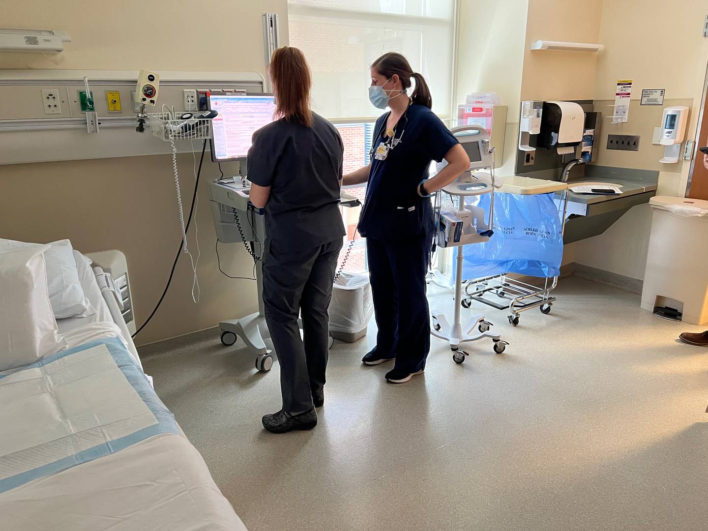 Nursing student Katie Strine, left, reads a patient's chart with clinical instructor Kerstin Koorey in the Surgical Acute Care unit at the University of Maryland Medical Center. April 18, 2023