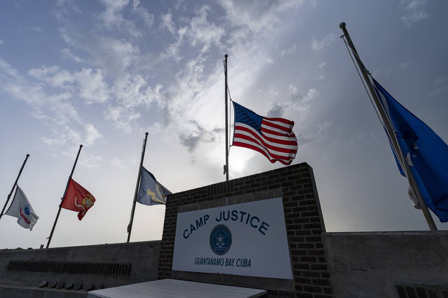 FILE - In this photo reviewed by U.S. military officials, flags fly at half-staff at Camp Justice, Aug. 29, 2021, in Guantanamo Bay Naval Base, Cuba. Majid Khan, the onetime courier for al-Qaida is a free man after serving more than 16 years at Guantanamo, and surviving torture at notorious CIA "black sites." The Pentagon announced the release of Pakistan citizen Khan on Thursday, Feb. 2, 2023. Khan is now in Belize, after that nation reached agreement with the Biden administration to take him.