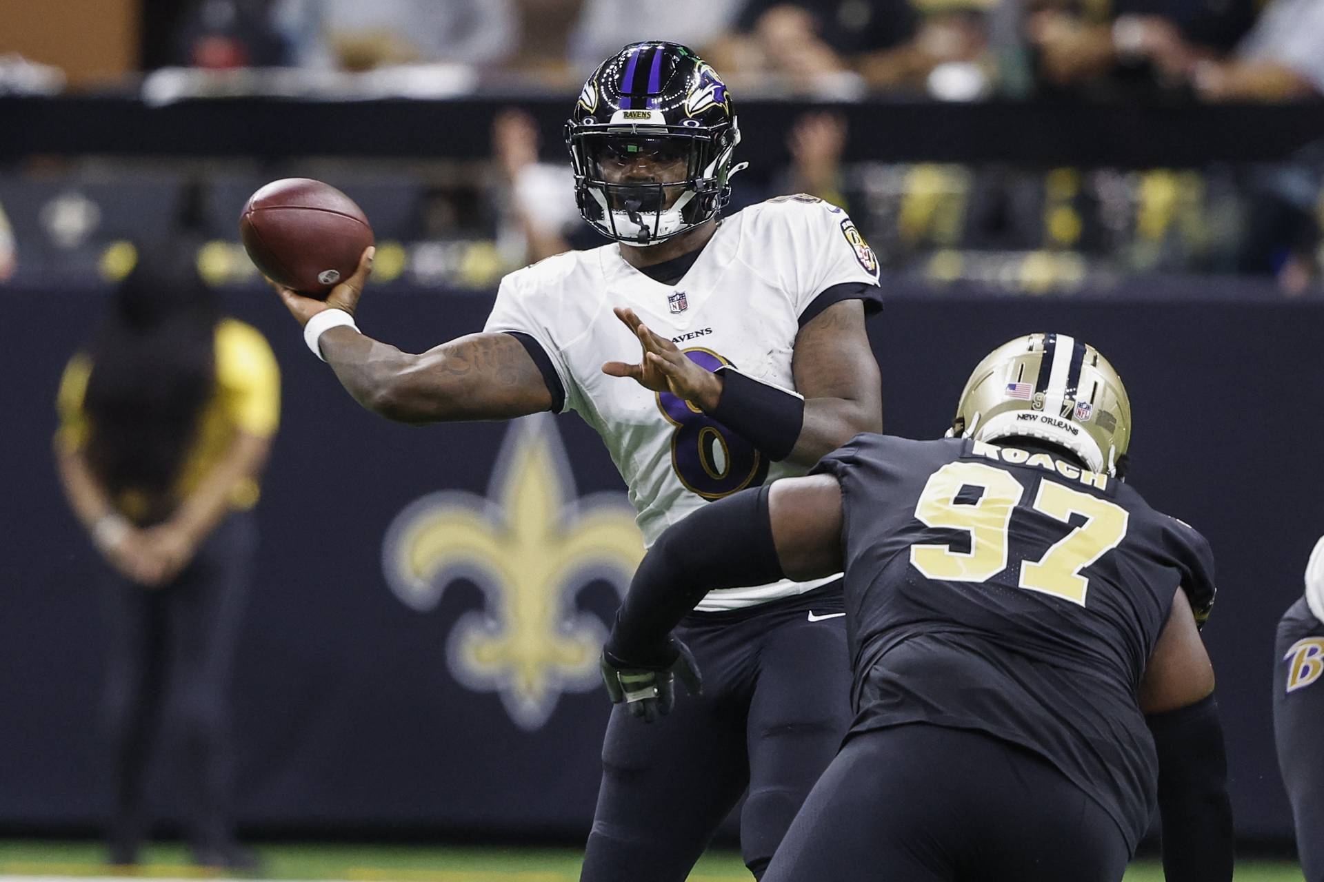 Baltimore Ravens quarterback Lamar Jackson (8) passes under pressure from New Orleans Saints defensive end Malcolm Roach (97) in the second half of an NFL football game in New Orleans, Monday, Nov. 7, 2022.