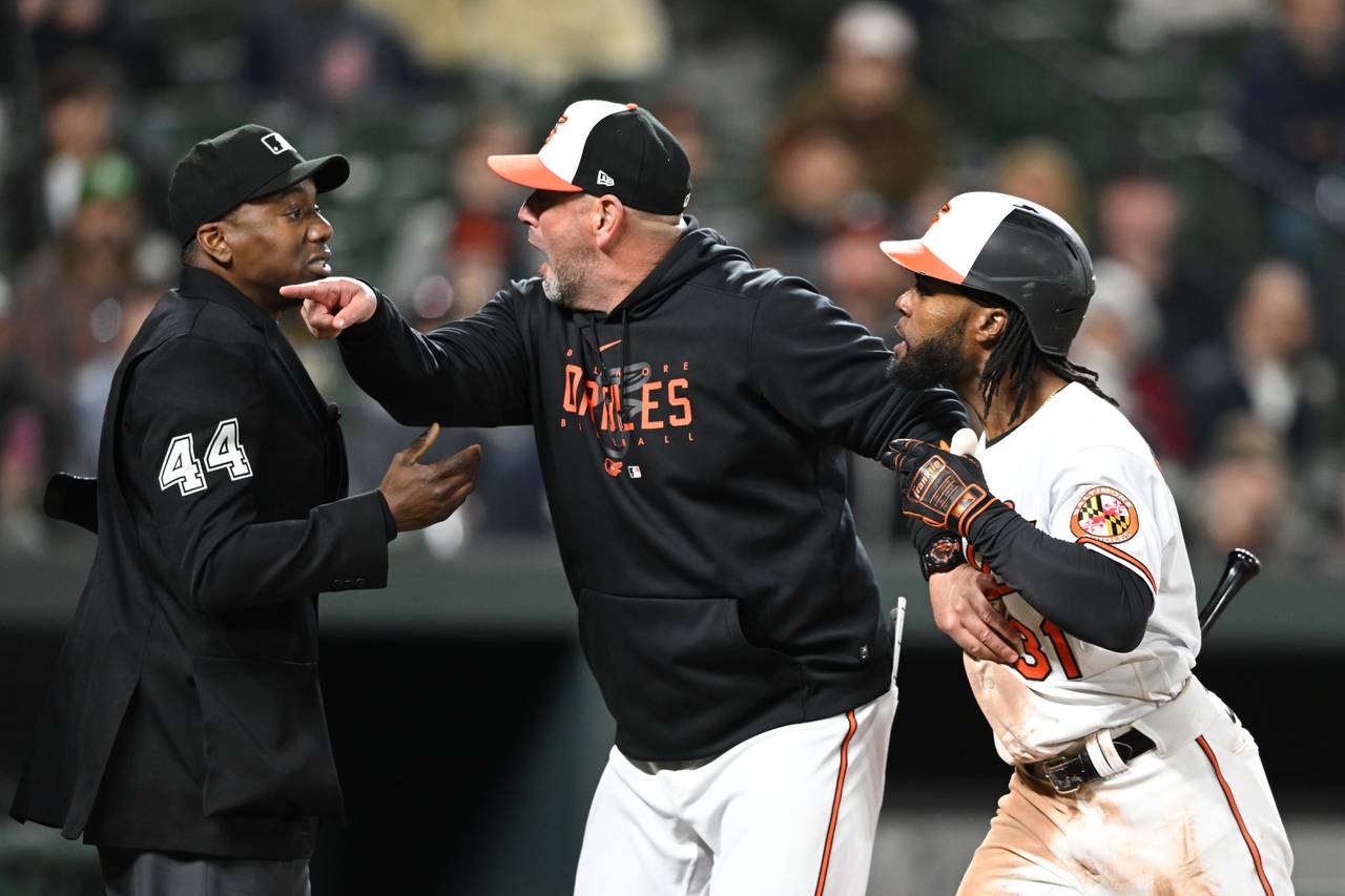Baltimore Orioles manager Brandon Hyde shields Cedric Mullins as he argues with home plate umpire Malachi Moore inn the seventh inning of a baseball game on Monday, April 10, 2023, in Baltimore.