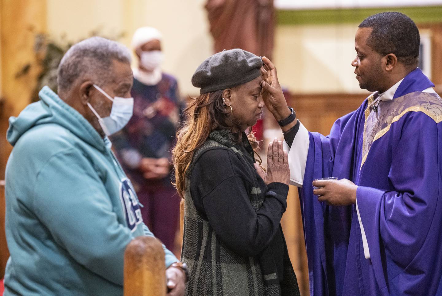 Catholic faithfuls participate receive the cross on their foreheads in ash from Fr. Xavier Edet, SSJ, in the celebration of Ash Wednesday at St. Francis Xavier Church, in Baltimore, Wednesday, February 22, 2023.