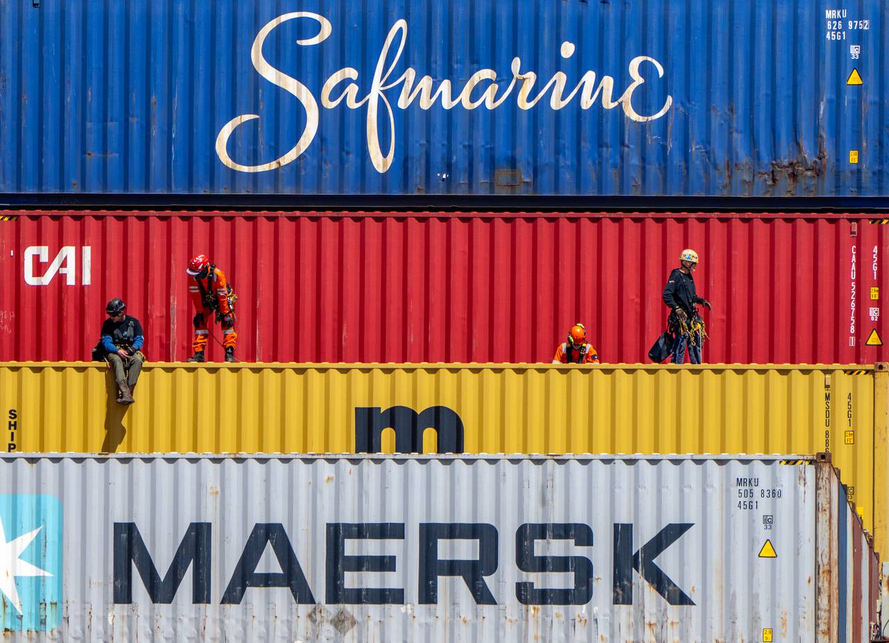 Workers are seen atop shipping containers on the Dali on Tuesday, April 16, 2024.