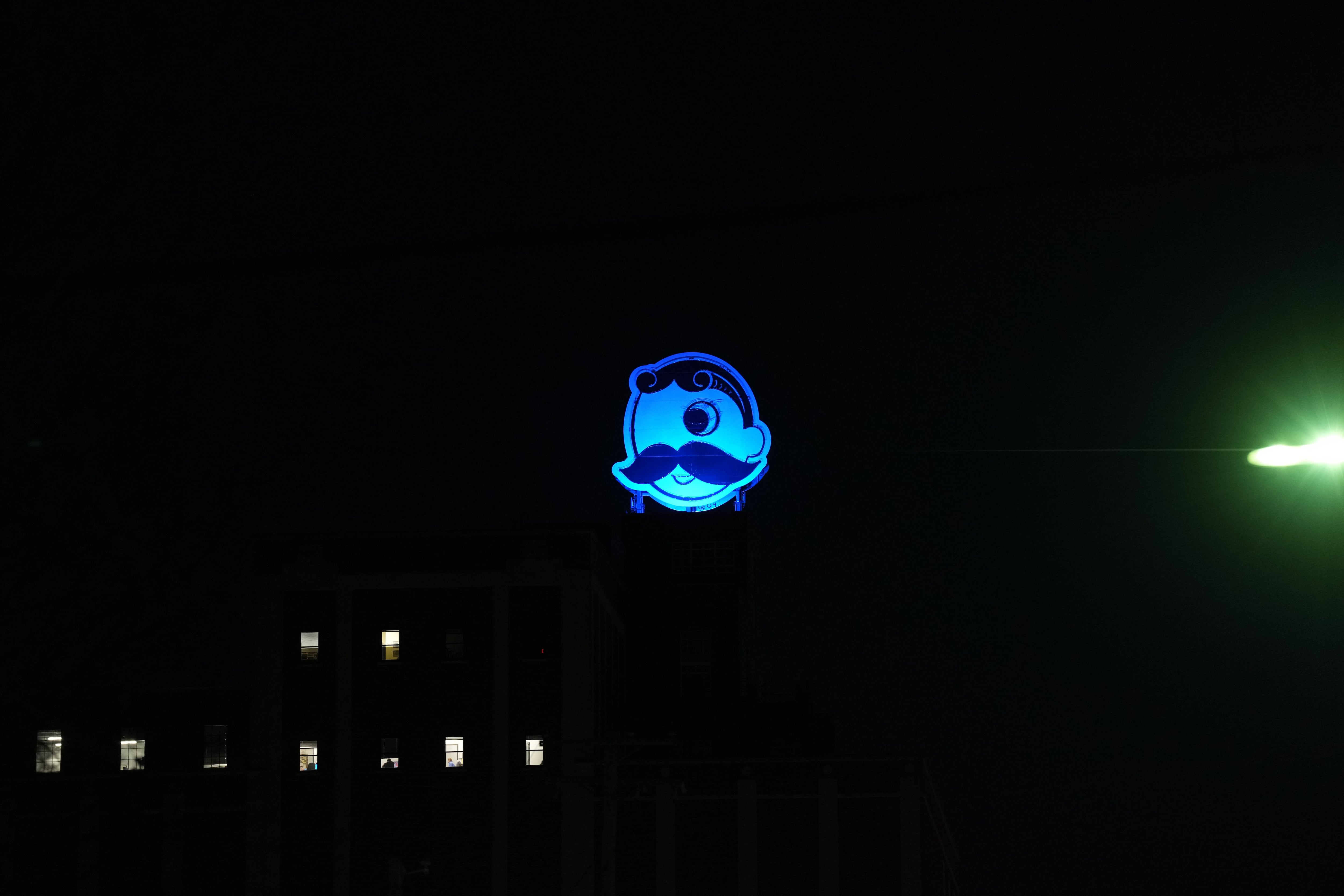 The neon Natty Boh logo glows blue at the top of the former National Brewing Company plant in Brewers Hill.
