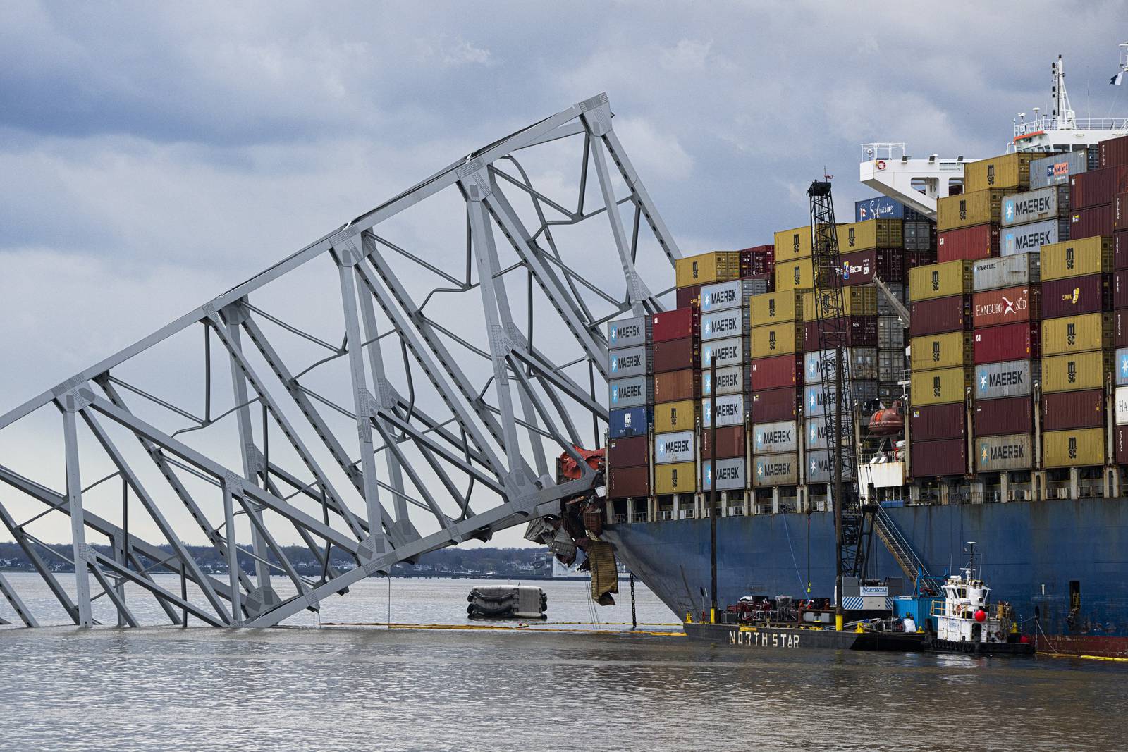 The site of the collapsed Key Bridge and the container ship that toppled it, The Dali, are seen from a debris retrieval vessel, The Reynolds, on April 4, 2024.