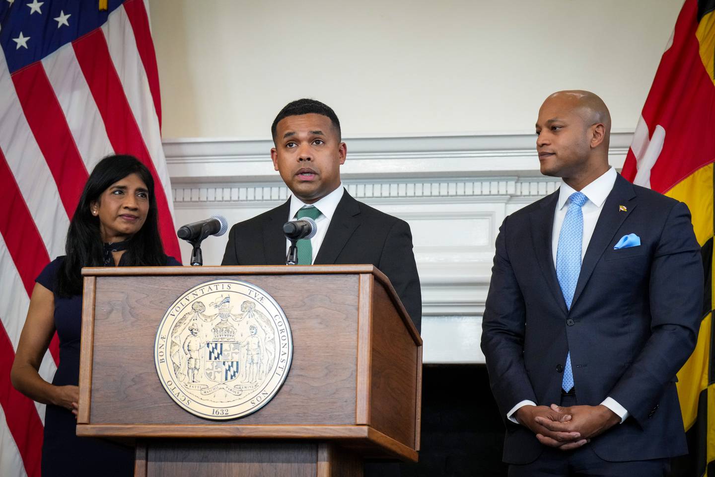 Paul Monteiro, center, speaks after being announced as Gov. Wes Moore’s pick to serve as the first secretary of the Department of Service and Civic Innovation at a press conference in the Maryland State House on Monday, April 3. Moore and Lt. Gov. Aruna Miller, left, stand behind Monteiro as he addresses the room. Moore issued an executive order creating the cabinet-level department on his first full day in office in January.