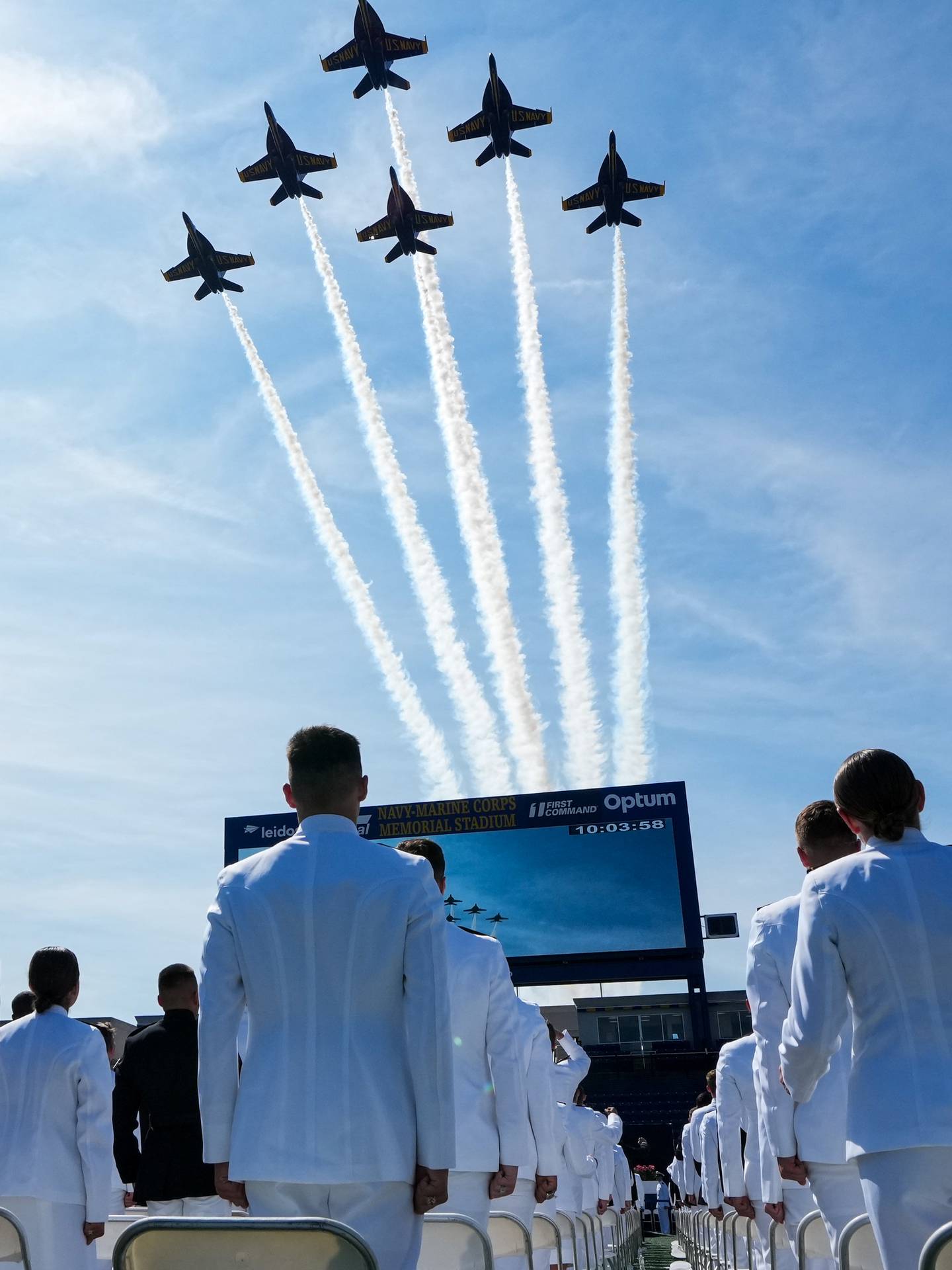 Graduating midshipmen watch as the Blue Angels perform a flyover during the U.S. Naval Academy’s graduation ceremony at the Navy-Marine Corps Memorial Stadium on May 26, 2023. The graduating midshipmen are commissioned as either an ensign in the U.S. Navy or a 2nd Lieutenant in the U.S. Marine Corps.