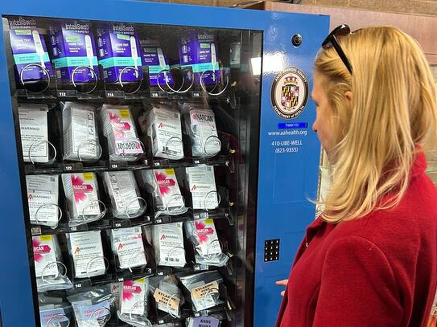 Christine Feldman, director of communications for the Anne Arundel County library system, shows how new vending machines, stocked with naloxone, work during a demonstration on March 11, 2024.