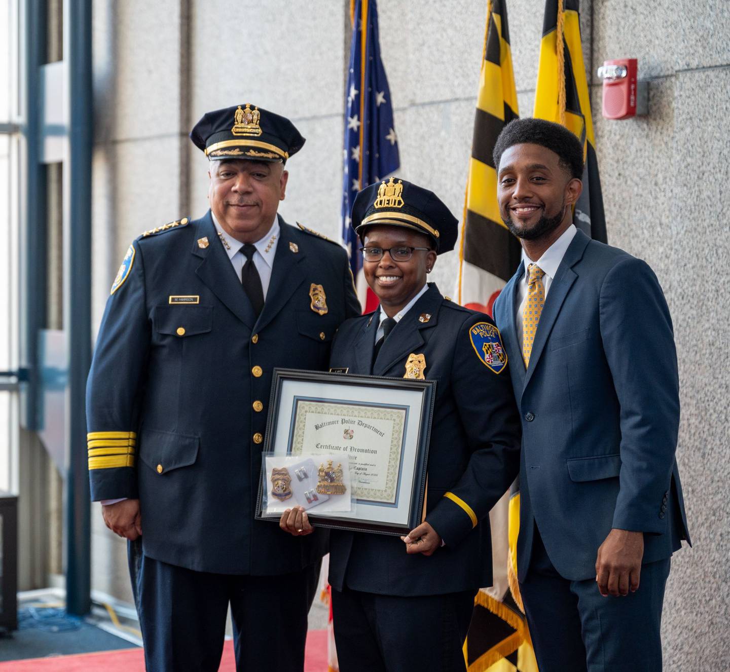 Baltimore Police Commissioner Michael Harrison, left, and Mayor Brandon Scott, right, at the promotion to captain for Alicia White, whose name became known around the country after the death of Freddie Gray.