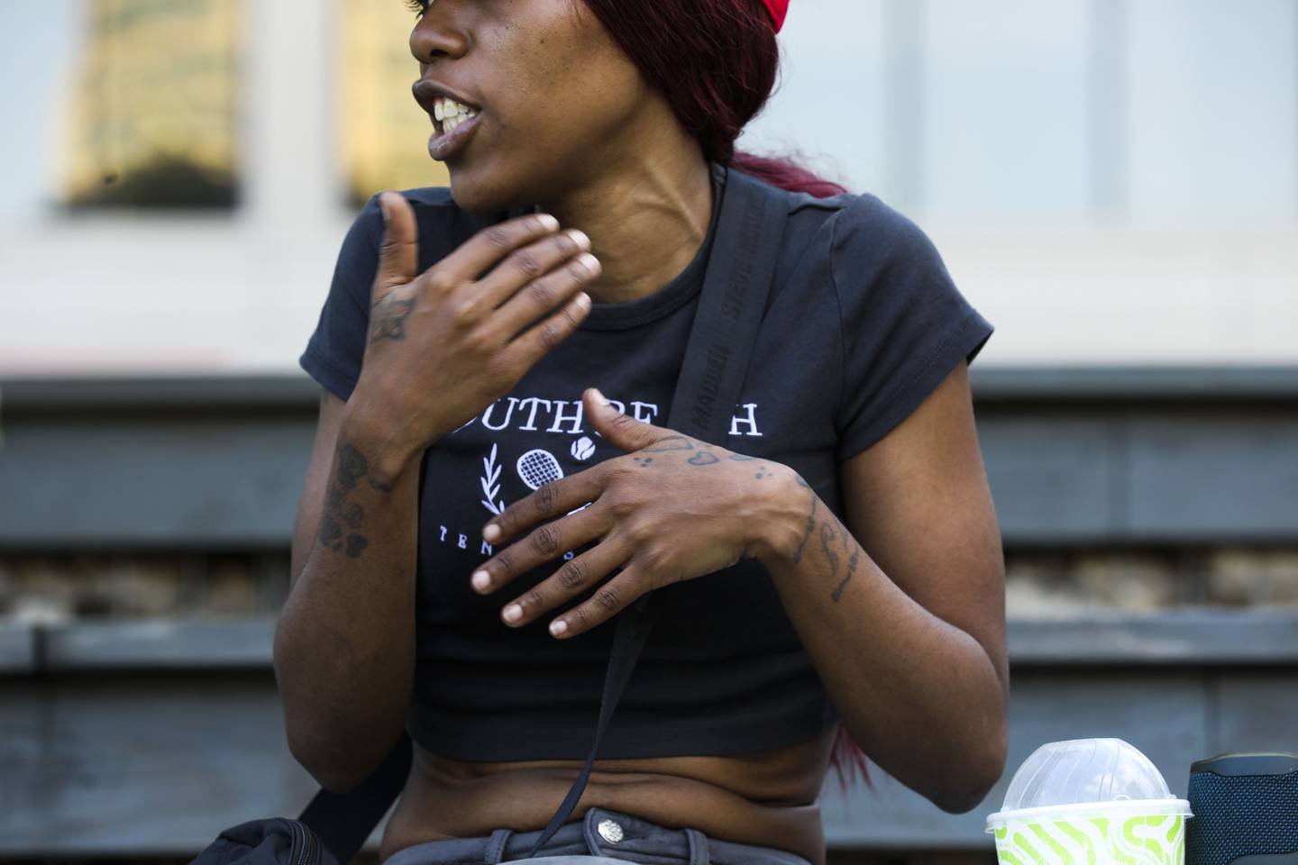 Aijah Gatson, 31, mother of the juvenile charged with murder in the squeegee shooting case, talks with reporters at McKeldin Square on August 3, 2022. She is accompanied by her other son, Tyree Gatson, 9, and her niece Milan Gatson, 11. She was on the phone with her son who is currently in custody.