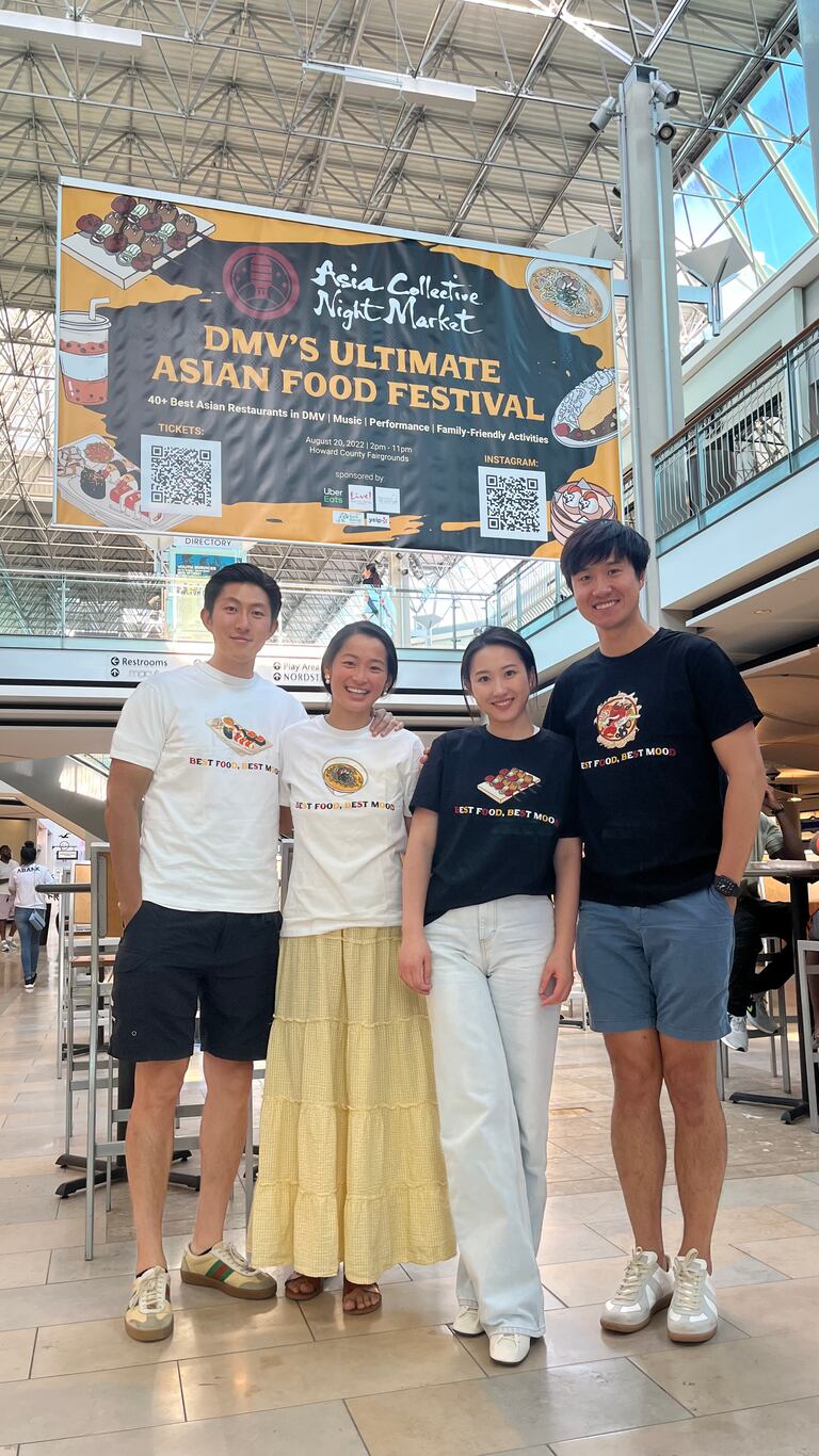 Asia Collective Night Market co-founders, (from left to right) Yumin Gao, Sophie Shi, Pauline Liu and Ben Wang, stand in front of a sign advertising their food festival at The Mall in Columbia. The night market will be held at the Howard County Fairgrounds on Aug. 20, 2022.