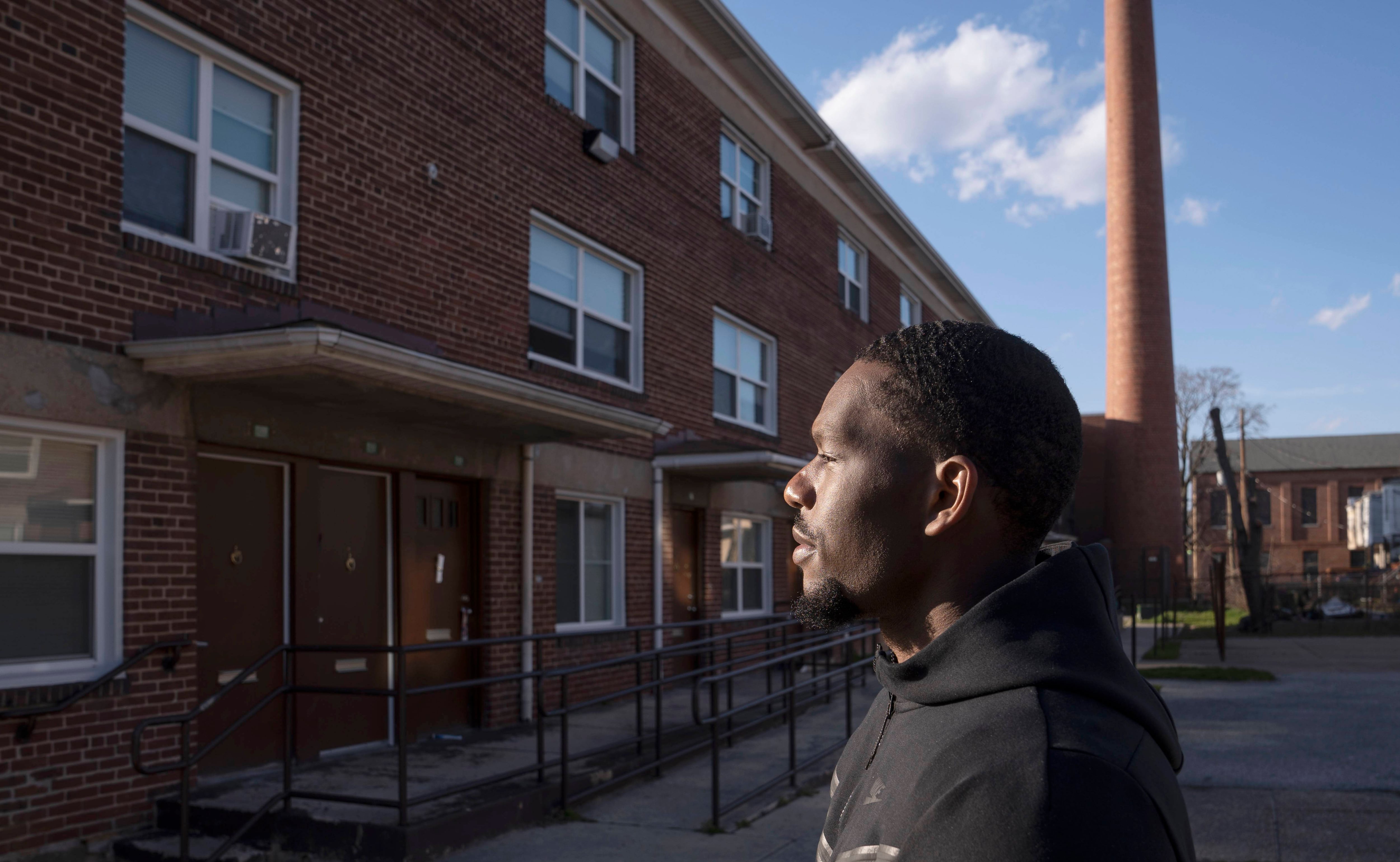 Lamar Richards, a current resident of DC, poses for portraits near his childhood home in Baltimore, Wednesday, March 29, 2023.
