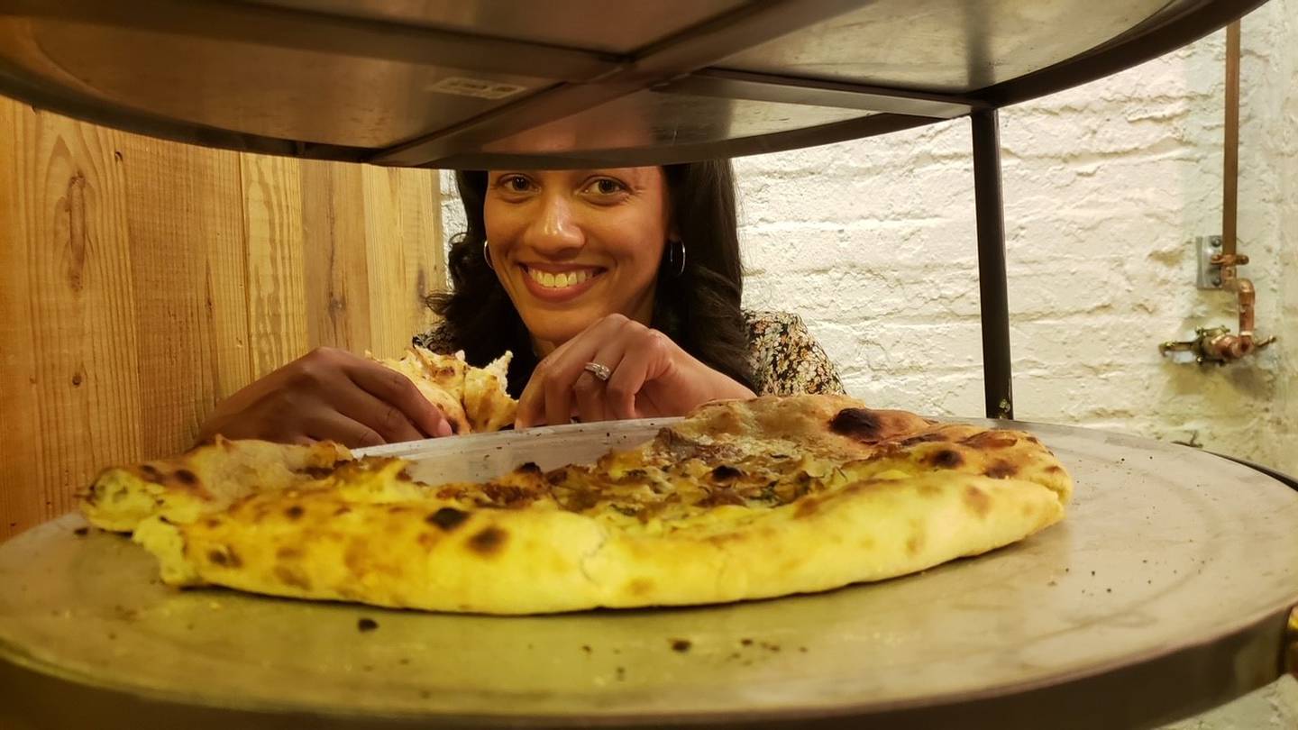 Jamyla Krempel peeks out behind a two-tier pizza tower at JBGBs.