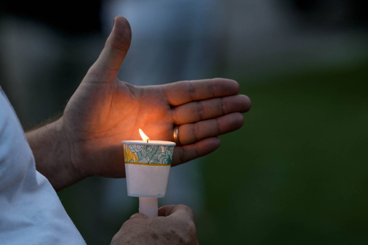 An attendee holds a candle at the ten year anniversary memorial gathering to honor Tyrone West held on the corner of Kitmore Road and Kelway Road on July 18, 2023. West was killed after being pursued by two officers of the Baltimore Police Department after he fled a traffic stop in 2013.