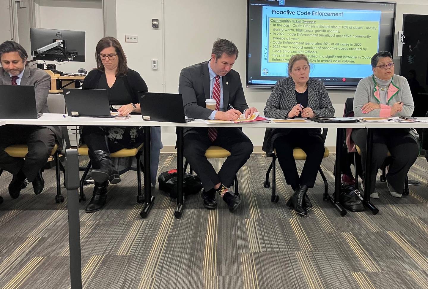 Baltimore County Executive Johnny Olszewski and members of his administration take notes during a county BC Stat meeting.