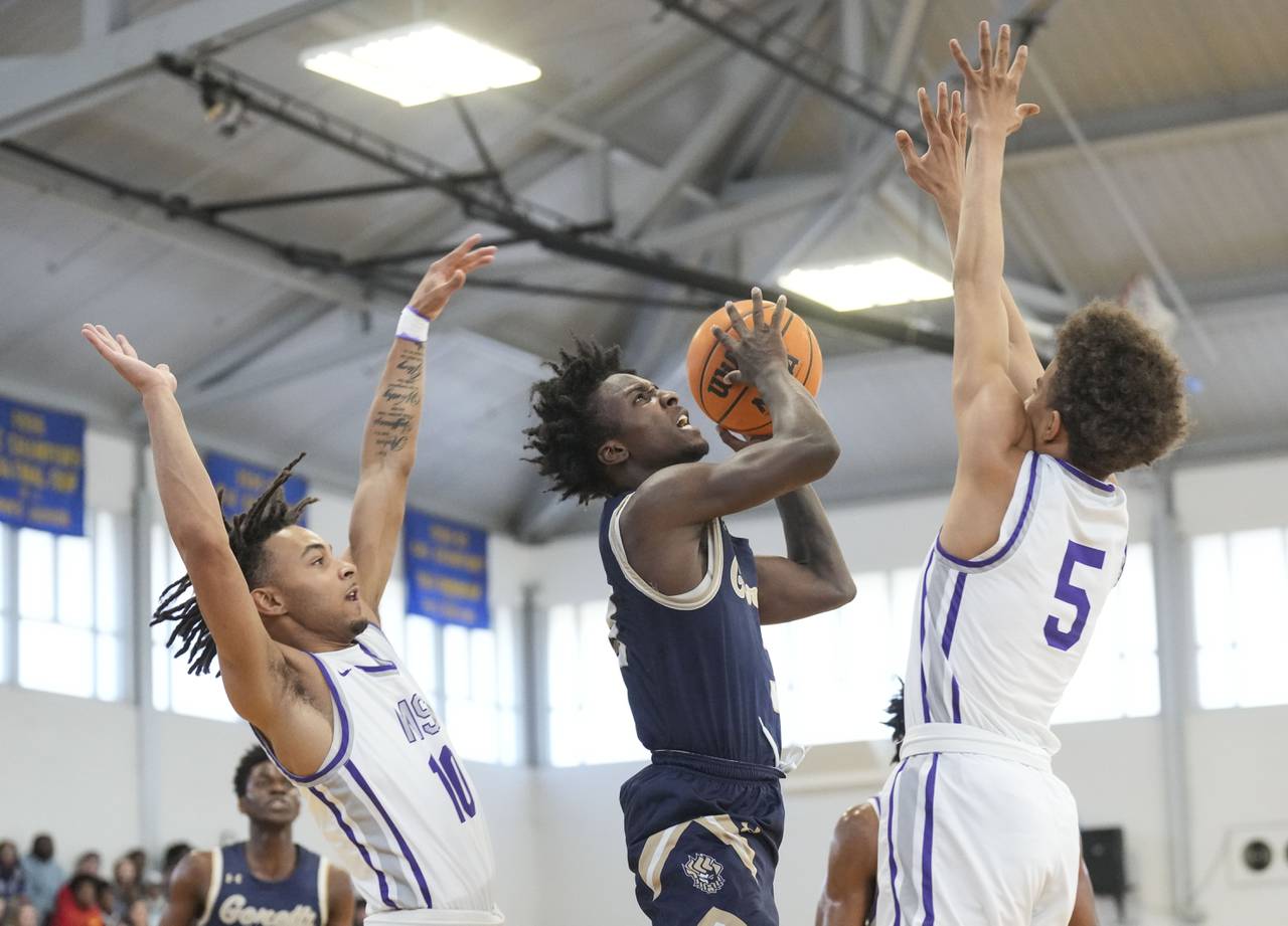 Mount St. Joseph Sean Clark (10) and Mount St. Joseph DJ Wingfield (5) attempt to block a shot from St. Maria Goretti Jahsan Johnson (3) in the Baltimore Catholic League Tournament championship at Goucher College, in Baltimore, Sunday, March 5, 2023