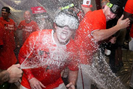 Baltimore Orioles right fielder Heston Kjerstad (13) is sprayed with champagne by teammates in the clubhouse following their playoff-clinching win against the Tampa Bay Rays on Sunday, September 17, 2023. The Orioles earned a spot in the playoffs for the first time since 2016.