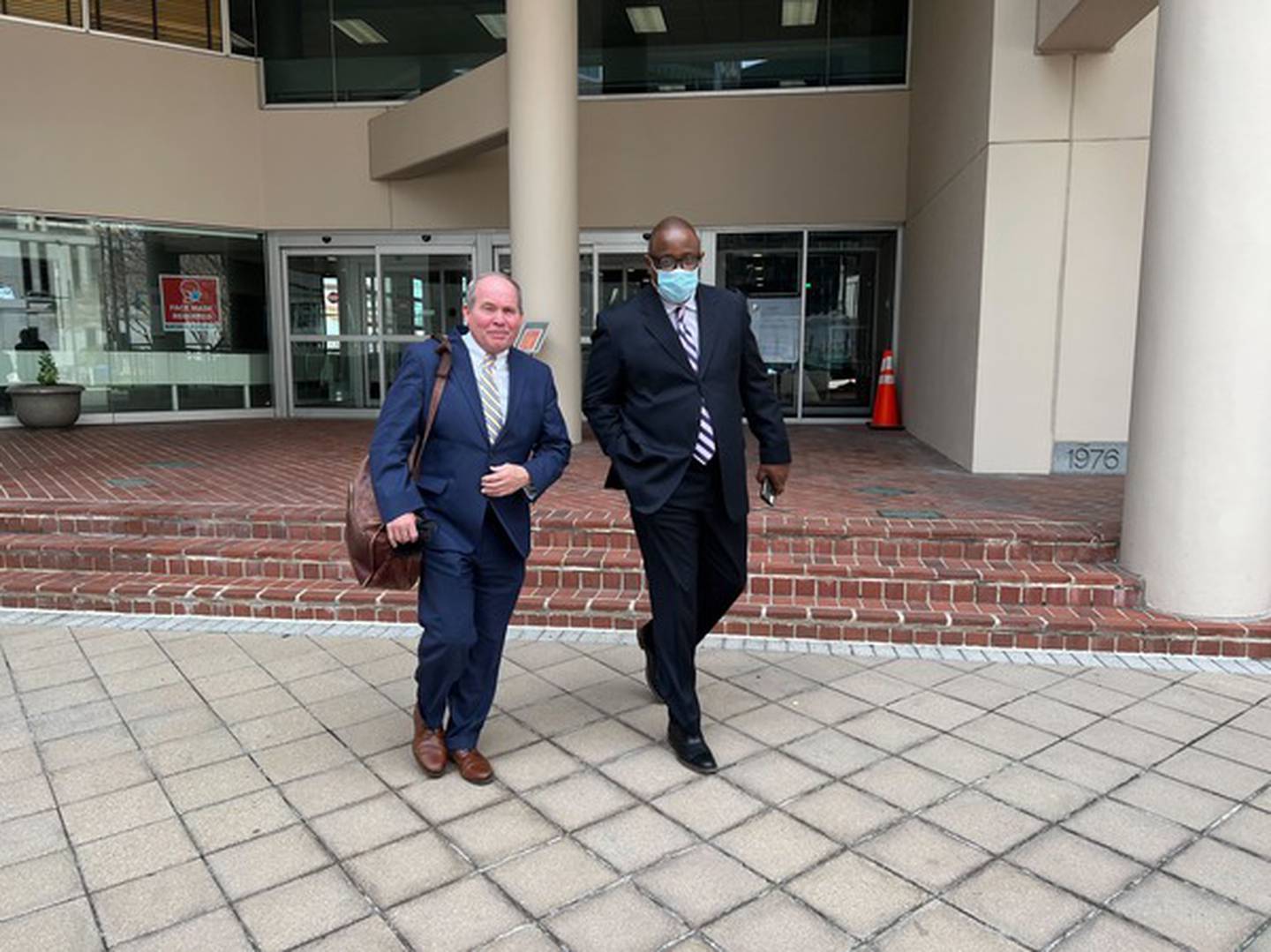 Baltimore Police Det. Ethan Glover, right, walks out of the downtown Baltimore federal courthouse with his attorney, Joseph Murtha, after a motions hearing Friday. Glover is accused of stealing money from a search warrant scene in 2016.