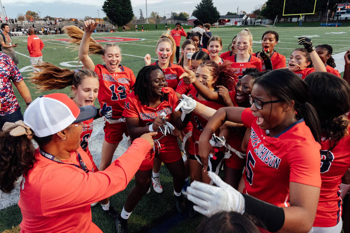 The Thomas Johnson Patriots celebrate after winning the last regular season game against the Frederick County Cadets, and clinching a postseason appearance in the first girls flag football season offered by Frederick County Public Schools in partnership and the Baltimore Ravens, at Thomas Johnson High School, on Thursday, Oct. 26, 2023 in Frederick, MD. (Wesley Lapointe / for the Baltimore Banner)