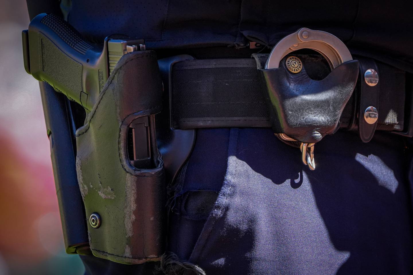 A Baltimore Police detective’s service pistol and handcuffs are secured on his belt as he observes the crowd in between innings during a baseball game against the Oakland Athletics held at Camden Yards on Wednesday, April 12. The Orioles beat the Athletics, 8-7, to win the series.