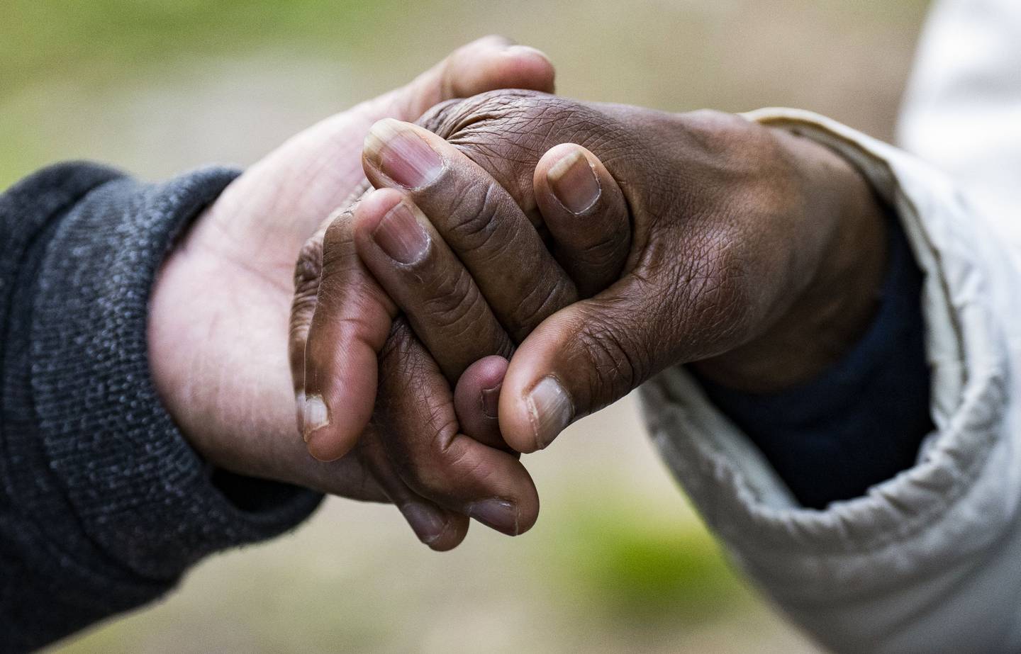 Members of the Good Trouble Church hold hands in prayer during the church’s Family Life service at The Ynot Lot in Baltimore, May 11, 2023.