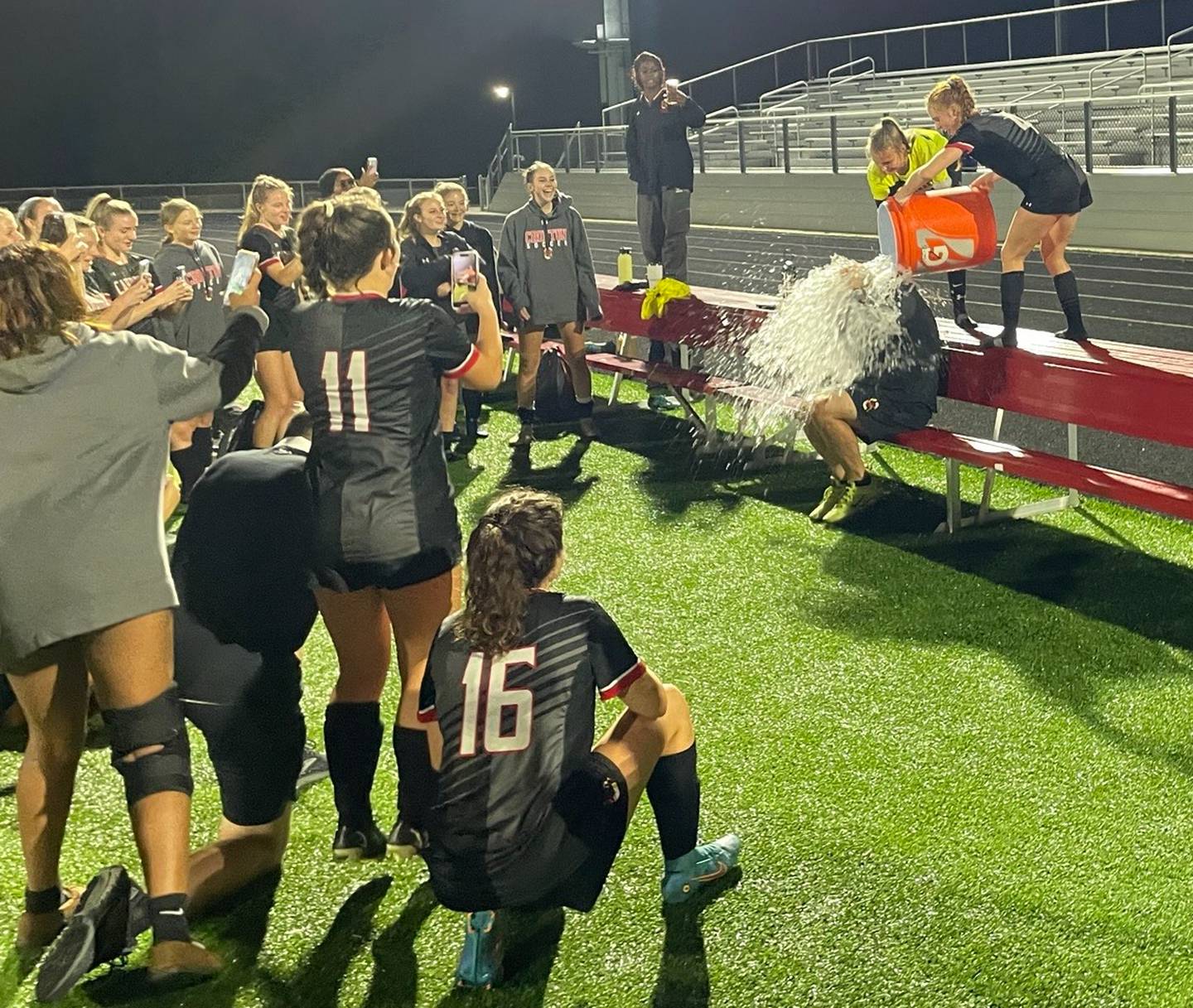 Crofton soccer coach Jason Bonfigli (sitting) gets a celebratory water dumping after Friday's overtime victory over Towson. The Cardinals, in its second varsity season, advanced to the Class 3A state semifinals with a 1-0 decision in Anne Arundel County.