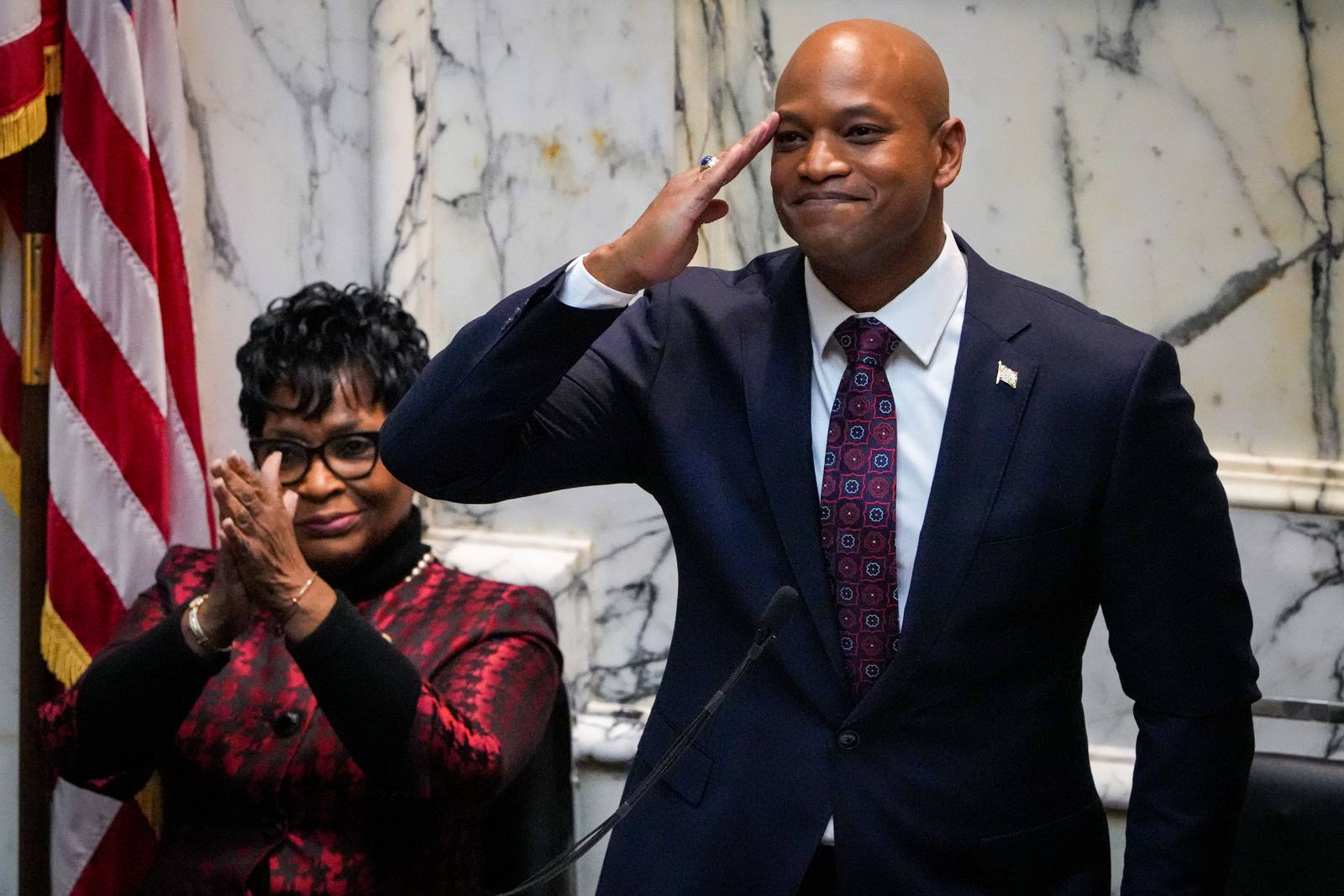 Gov. Wes Moore, standing in front of House of Delegates Speaker Adrienne A. Jones, salutes as he delivers his first State of the State address on 2/1/23 at the Maryland State House.