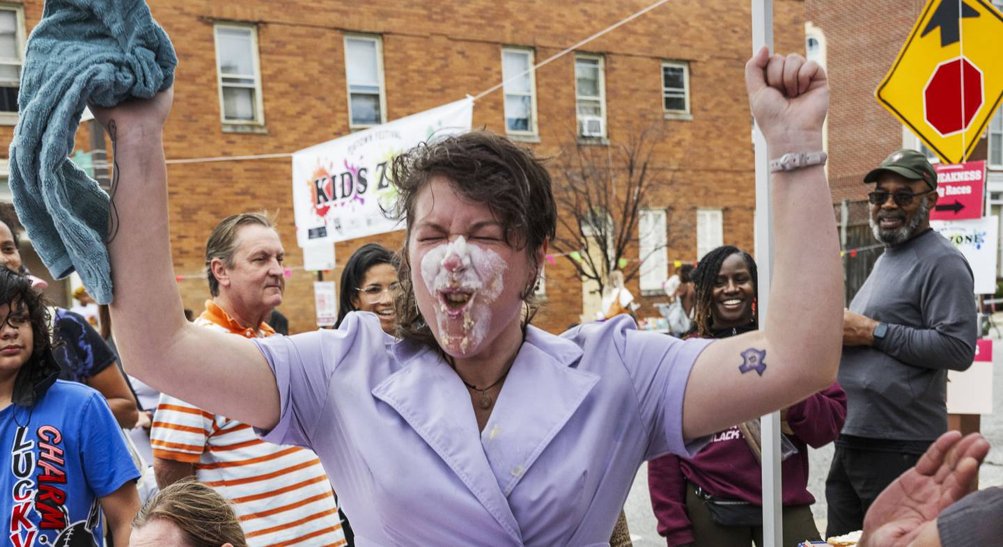 Steph Compton celebrates winning a pie eating contest during the Pigtown Festival in Baltimore, MD on September 30, 2023.