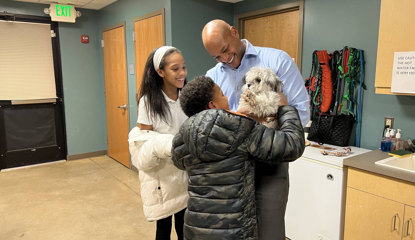 Gov. Wes Moore, right, and his kids Mia, left, and James hold Tucker the dog.