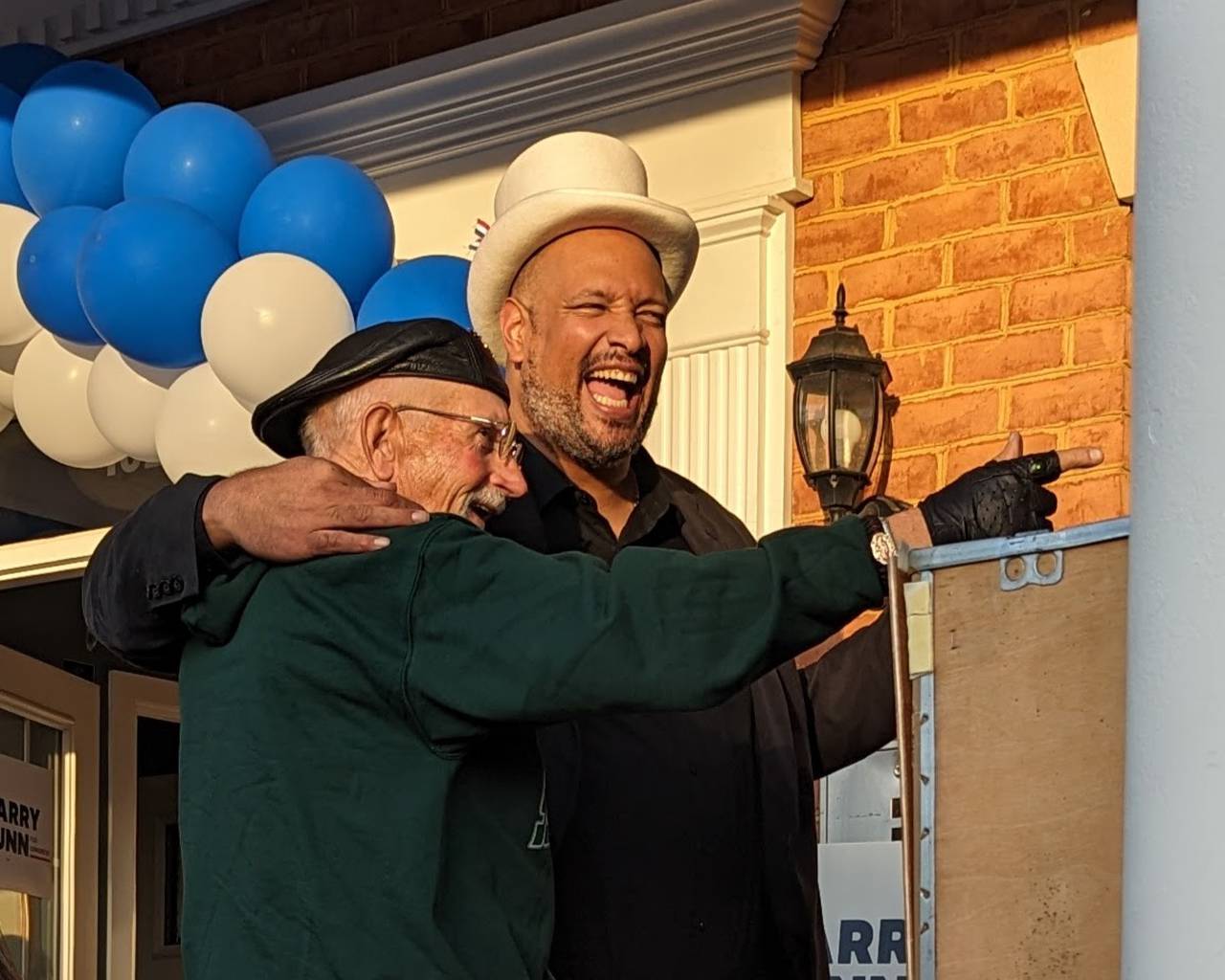 Harry Dunn, a candidate for Congress in the 3rd District, dons a silly hat and laughs with a supporter at the opening of his campaign headquarters in Ellicott City.