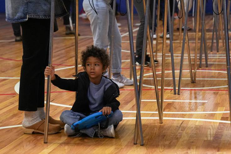 Keegan, 6, sits on the floor of Margaret Brent Elementary/Middle School’s gymnasium as his mom, Katrina Washington, votes on Election Day, Nov. 8, 2022. Polling locations for the general election remain open until 8 p.m.