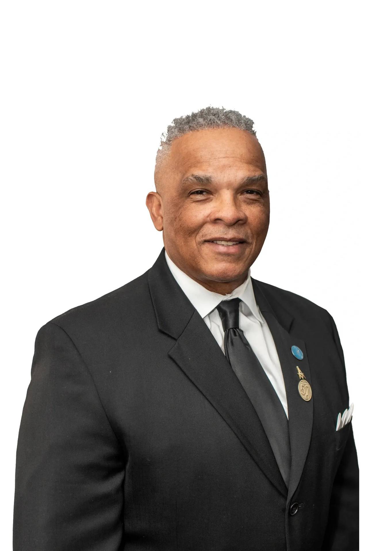 A photo of Marvin M. Briscoe wearing a black suit with a black tie and white shirt against a white background.