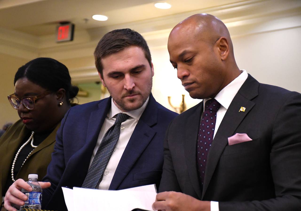 Maryland Gov. Wes Moore consults with Brad Fallon, his deputy legislative officer, ahead of testifying before the House of Delegates Environment and Transportation Committee on Tuesday, Feb. 20, 2024.