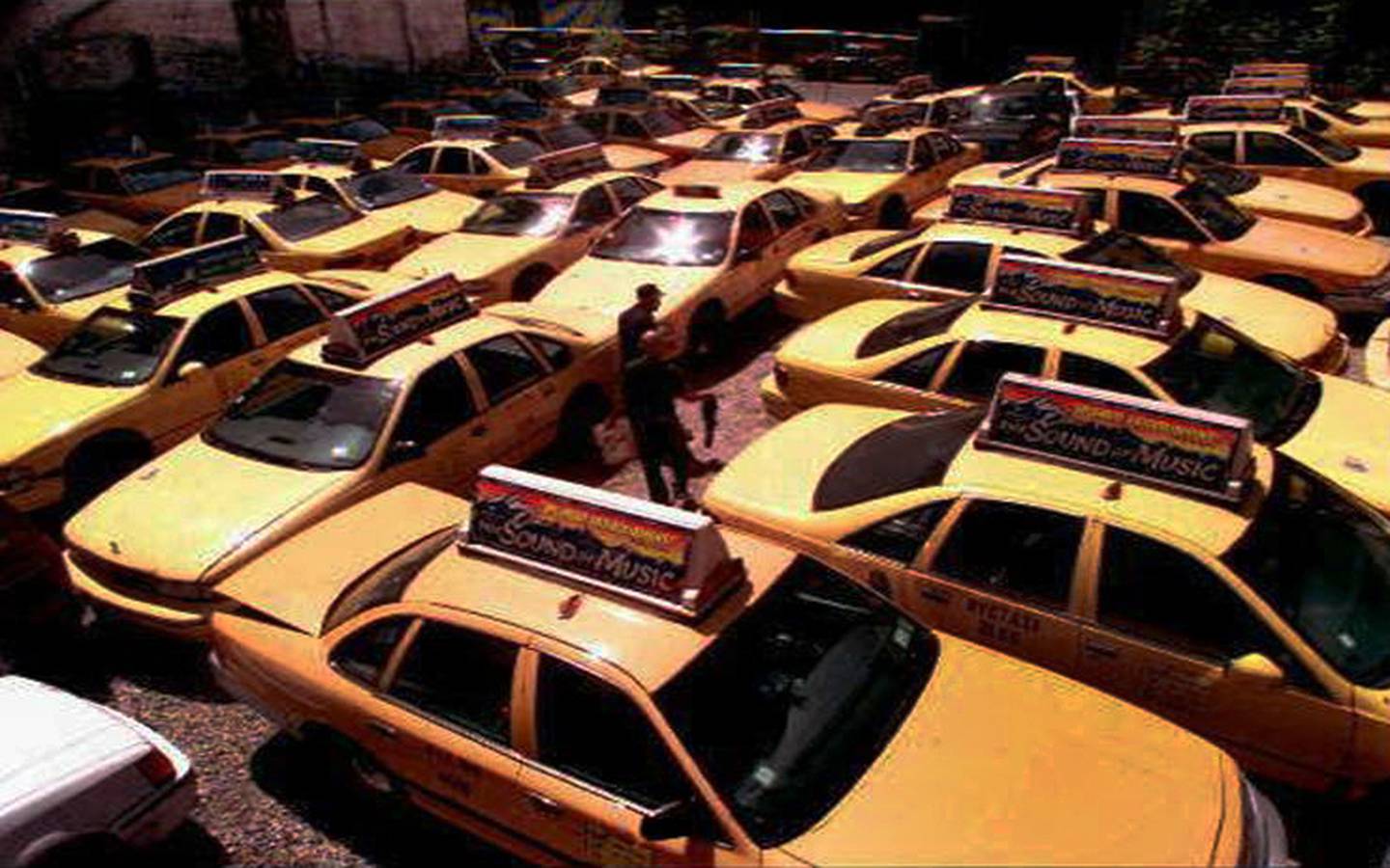 Yellow taxi fleet parked in lot, New York City, photo on black