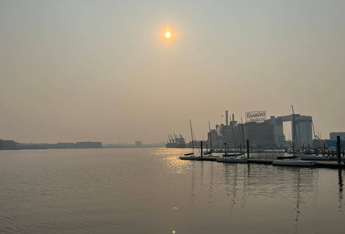 Smoke turns the sky hazy in downtown Baltimore in this photo of the Inner Harbor waterfront as the Domino Sugar sign sits in the distance.