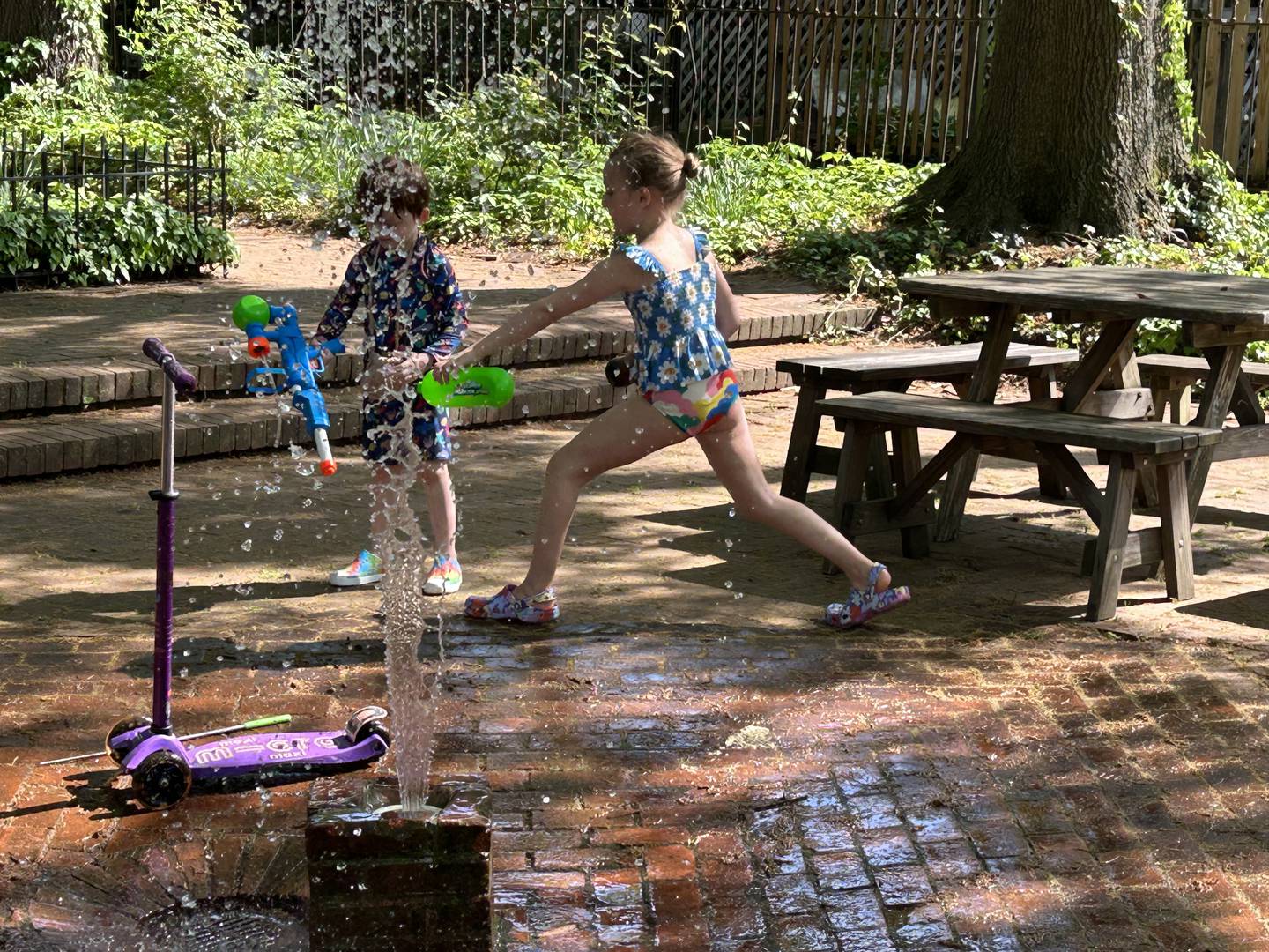 Children play in the splash fountain at Rutter's Mill Park in Bolton Hill Sunday afternoon.