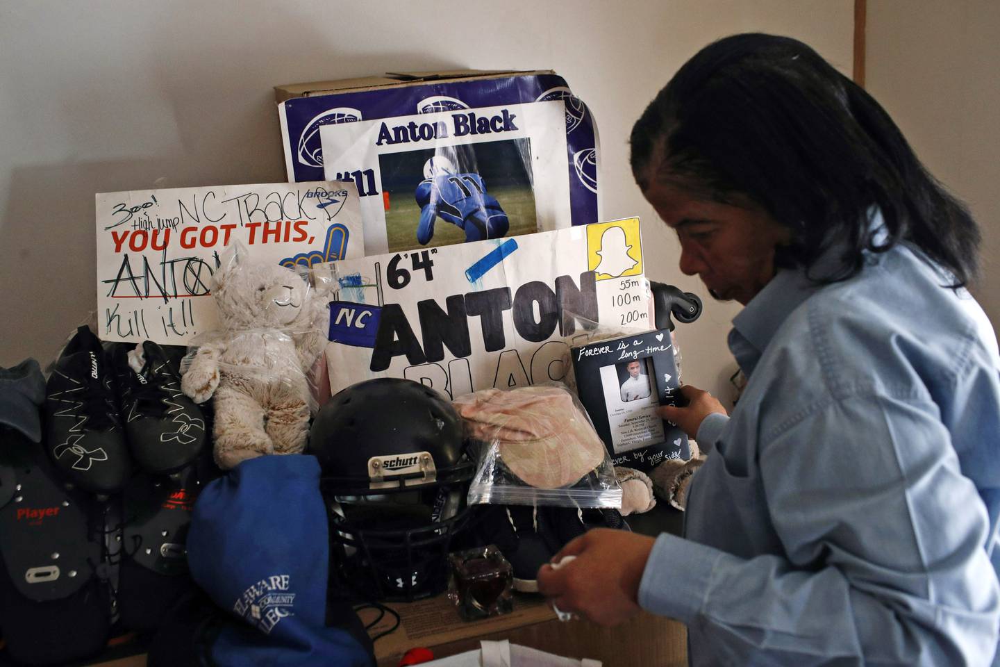 In this Jan. 28, 2019, file photo, Jennell Black, mother of Anton Black, looks at a collection of her son's belongings at her home in Greensboro, Md. Relatives of Anton Black, a 19-year-old Black man who died during a struggle with police officers on Maryland's Eastern Shore, have reached a $5 million partial settlement of their wrongful death lawsuit, an agreement that also requires improvements in police training and policies, family attorneys announced Monday, Aug. 8, 2022.
