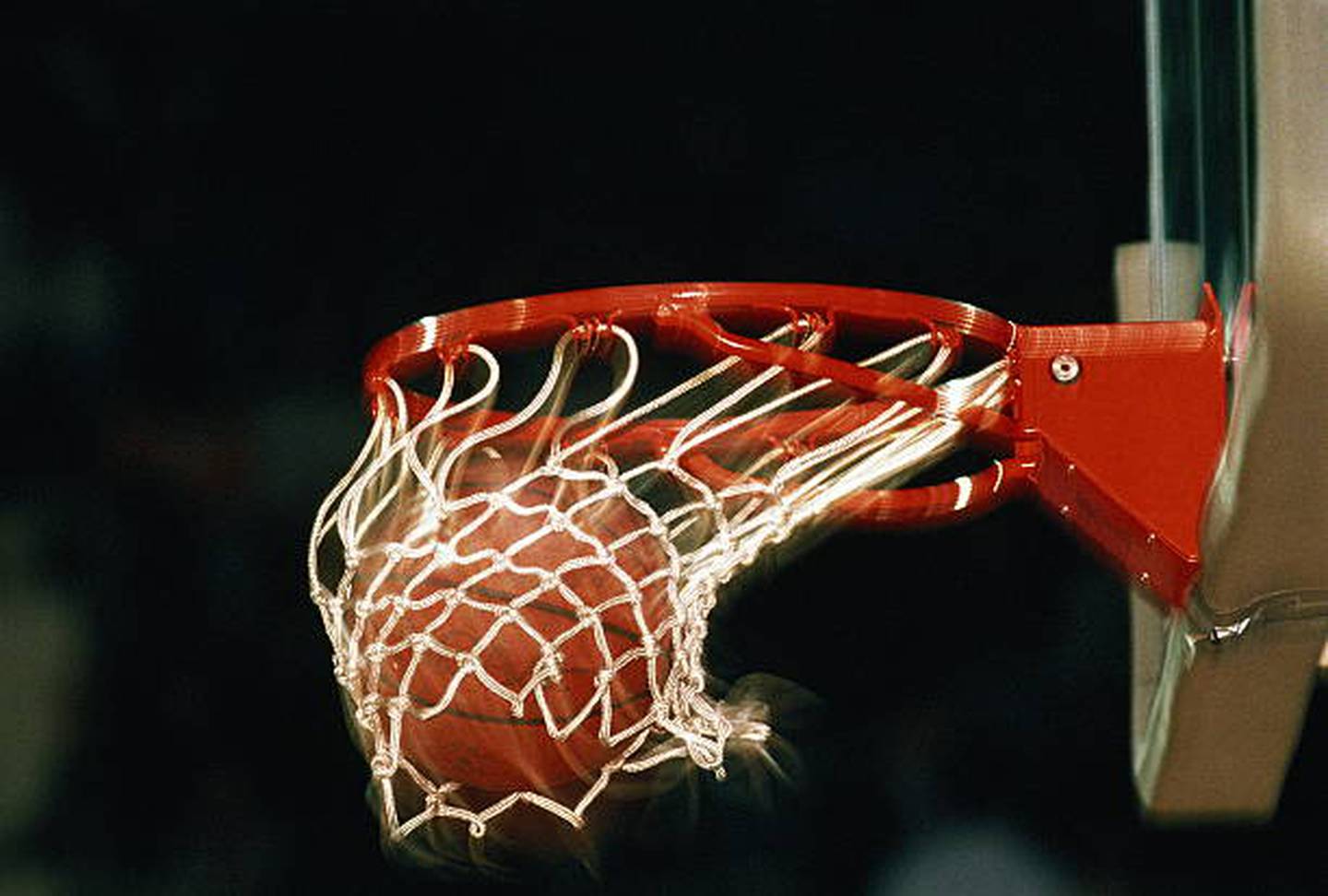A basketball in a basketball hoop.