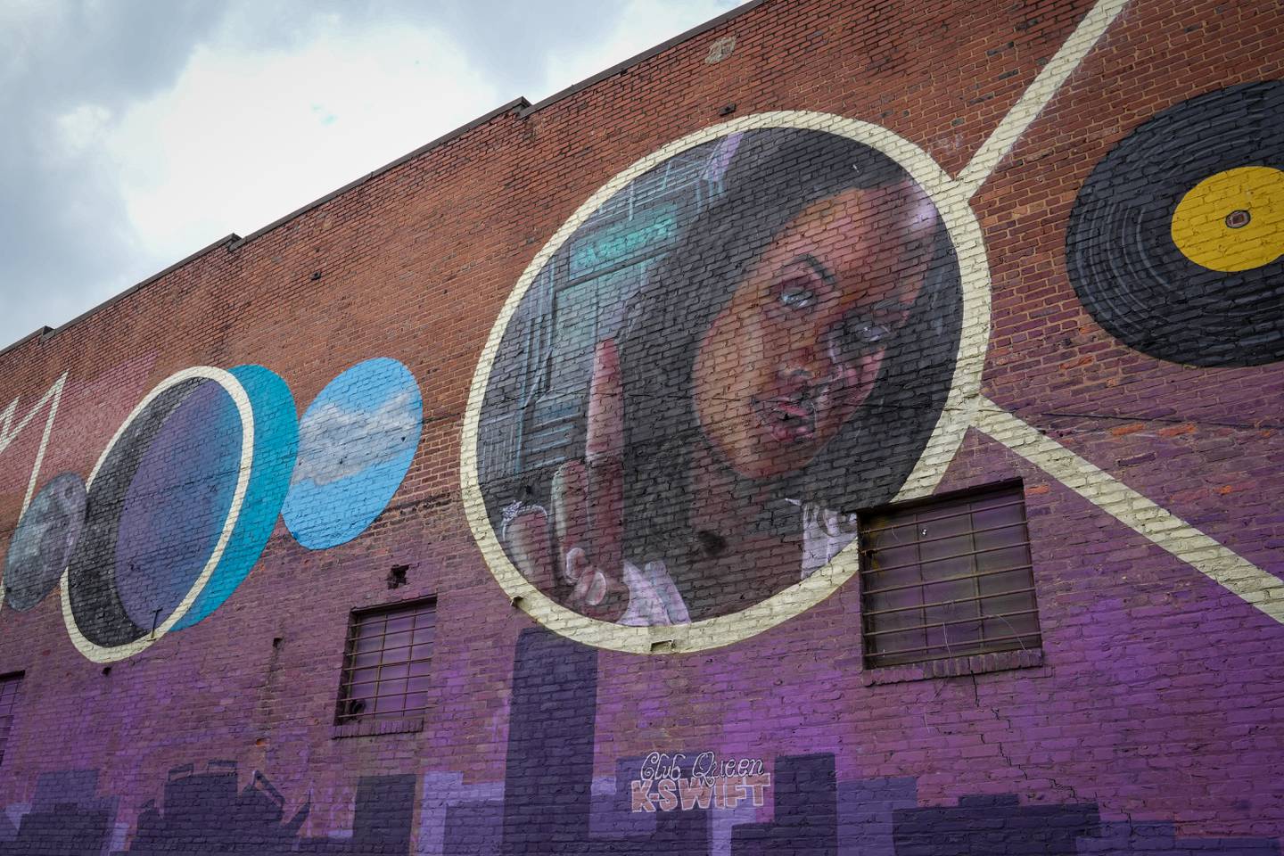 A mural of DJ K-Swift is painted on the wall of Hammerjacks in South Baltimore, painted by artist Nether410.