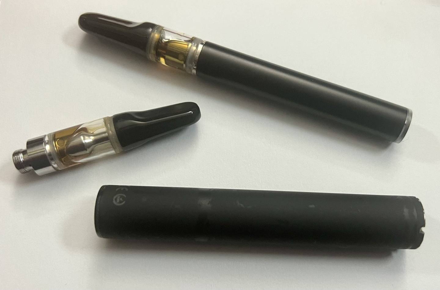 From top: Disposable cannabis vape pen, single cannabis oil-filled cartridge, and rechargeable battery to attach to cartridges.