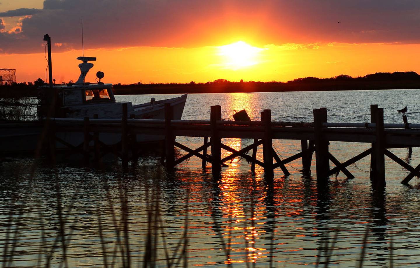 EWELL, MD - AUGUST 22:  The sun sets behind a fishing boat on August 22, 2011 in Ewell, Smith Island, Maryland.  on August 22, 2011 in Ewell, Smith Island, Maryland.